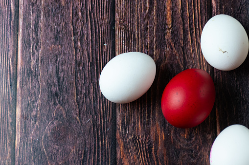 Red easter egg and white eggs on a table