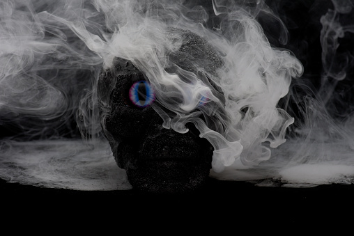 Homemade scary skull with menacing eyes with unique fog and mist patterns swirling round the skull created and made by photographer