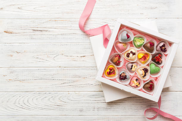 istock Holiday composition: sweet candy, with gift boxes with bow and chocolate hearts, photo template, background. Top View with copy space on colored background 2082963403
