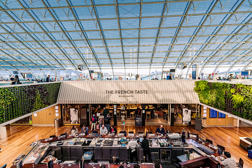 Editorial shot of bustling The French Taste restaurant at Paris Charles De Gaulle Airport on 1st November 2022 with travelers dining and staff working.