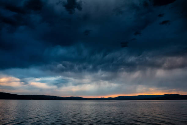 istock Storm clouds over a picturesque lake at sunset 2082983814
