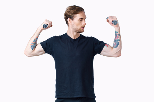 man with pumped up muscles of arms and dumbbells black t-shirt white background. High quality photo