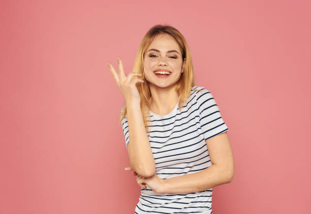 istock Beautiful blonde gesturing with her hands on a pink background model cropped view 2082989028