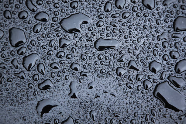 istock Drops of rain on a black rubber surface close-up. 2082990085