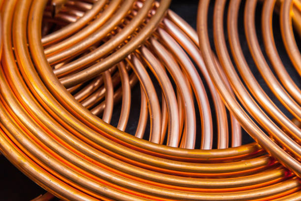 Twisted new copper tubes on a black background.