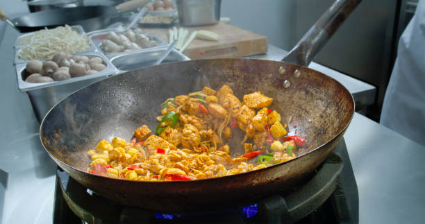 istock Chef tossing the wok while making a stir fry and using a ladle to mix it 2083036180