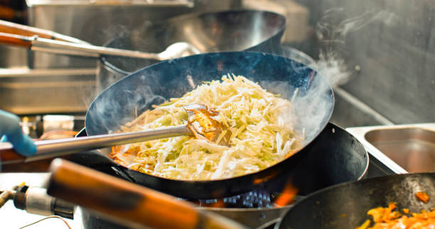 istock Chef preparing Asian food in restaurant kitchen 2083036196