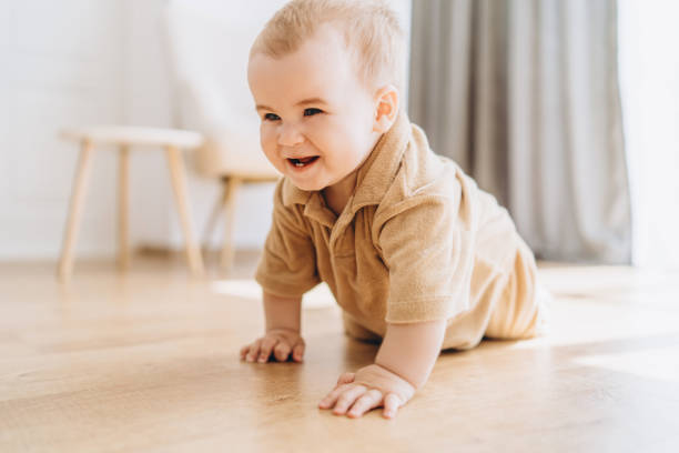 istock Baby crawling on floor in room 2083040601