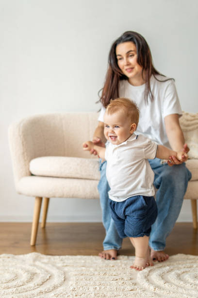 istock Woman sitting on couch holding baby 2083040615