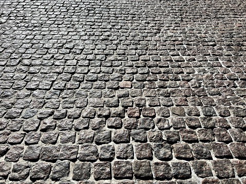 Cobblestone stone pavement road gray background.