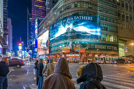 People on Times Square by night, NYC. A great billboard of the movie Flags of our fathers (by Clint Eastwood) can be seen.