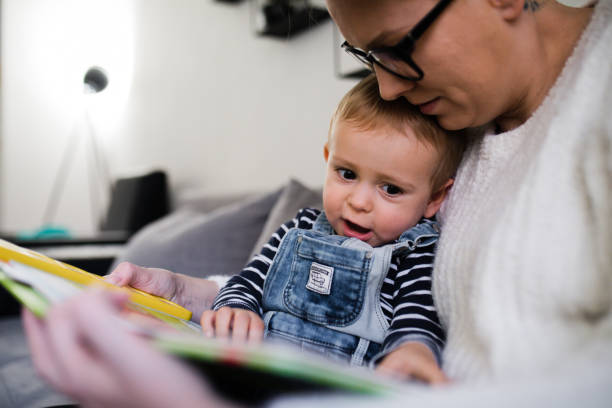 istock mom read book with son and sit on sofa at home 2083069195