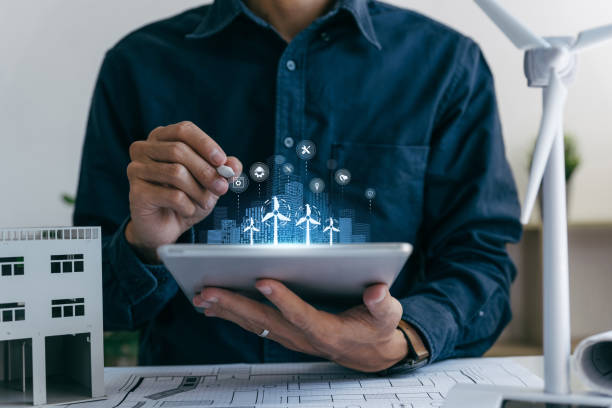 istock Architects engineer working on tablet with windmills, designing model of renewable wind house building. 2083074539