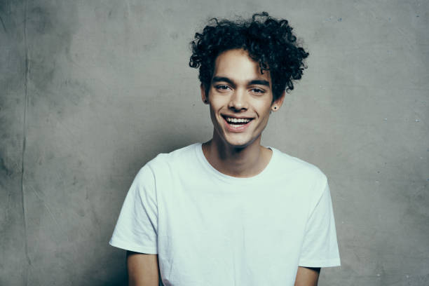 istock guy with curly hair in a white t-shirt sits on chairs studio 2083081974