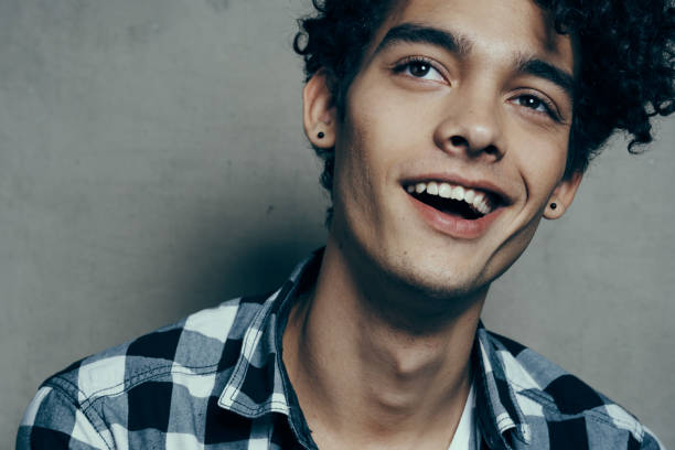 istock cute guy portrait curly hair emotions gray background model 2083086740