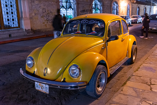 This picture shows the historic streets of San Cristóbal de las Casas, Mexico in February 2015. An old VW Beetle is parked on the side of the road.