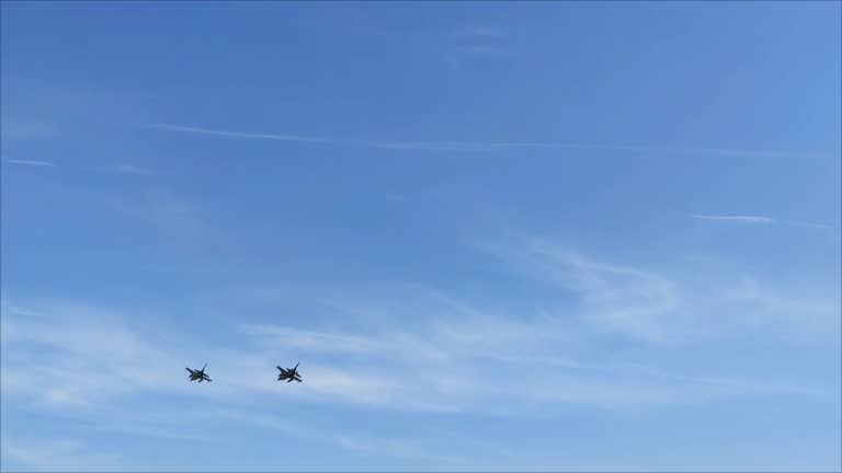 A military fighter aircraft flies in the blue sky