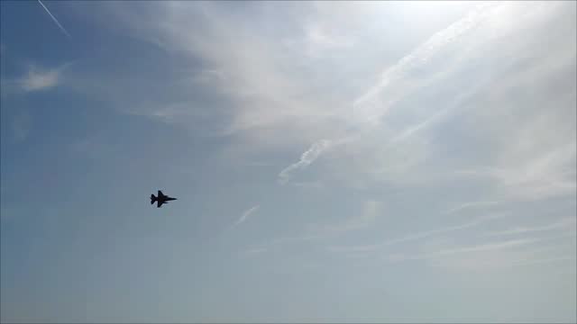 A military fighter aircraft flies in the blue sky