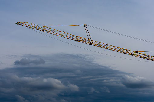 Crane girder over strorm clouds, building equipment