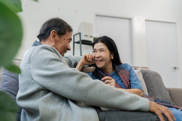 istock Older couples sit and chat and head over each other relaxed and happy on sofa at home on weekday in comfortable 2083131654