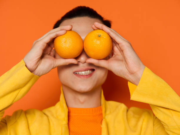 istock Handsome man with ripe oranges in front of his eyes charming smile 2083161407