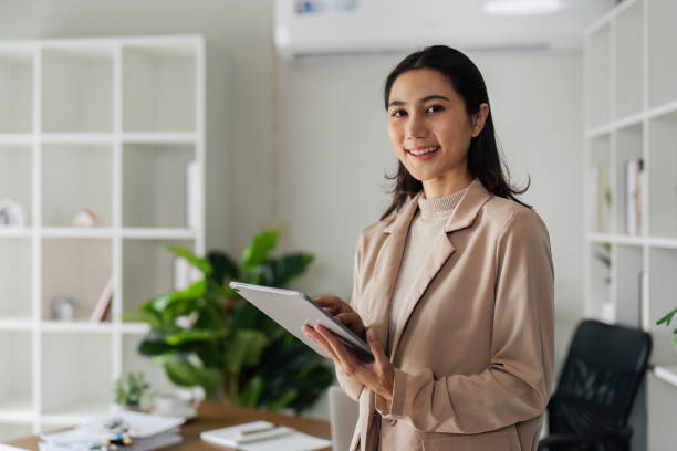 istock Confident Businesswoman using digital tablet while standing in front of desk 2083169988