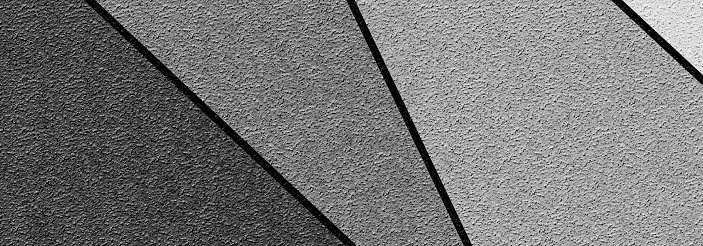 Black and white abstract geometric plaster background on coarse-grained wall.