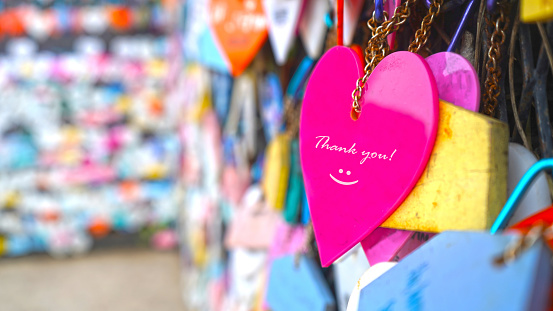 Colorful hearts on street with text message on pink color - Thank you. With happy smile emoticon sign. Thank you phrase. Showing grateful gratitude concept.