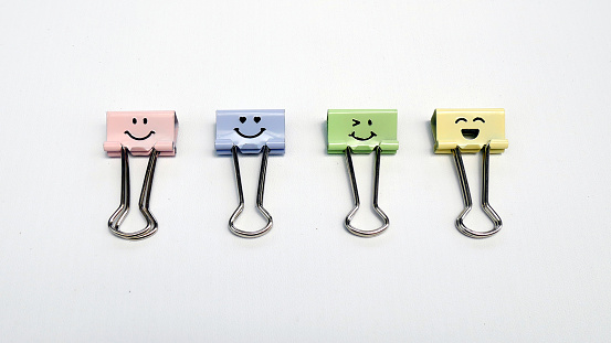 Binder clips, colorful paper clips on a white background