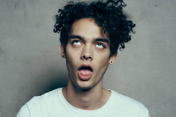 istock cute guy curly hair emotions studio cropped view 2083210897