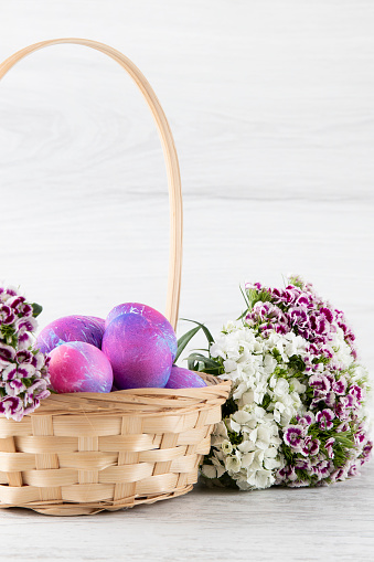 Pastel colored dyed Easter eggs on white rustic background.