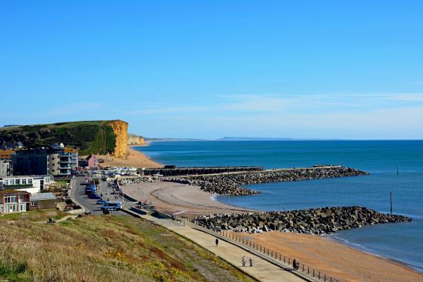 Elevated view across the town and harbour towards the Jurassic Coast seen from the South West Coast Path, West Bay, Dorset, UK, Europe.