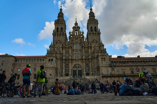 Santiago de Compostela, Spain - 09 27 2022: Tourists in front of the tall church of Santiago de Compostela in Galicia spain is the destination of the popular pilgrimage along the Camino de Compostela.