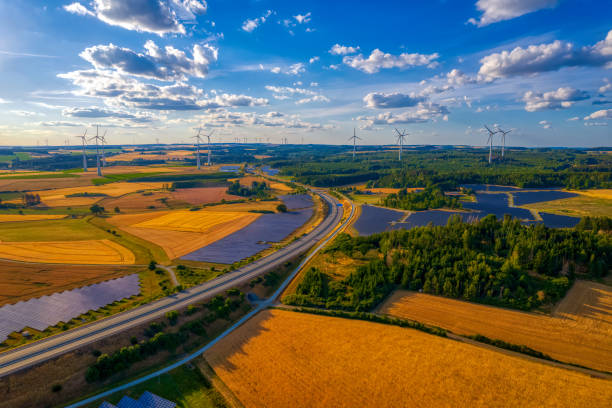 istock solar farm and wind turbines near the highway road interchange (aerial) 2083319621