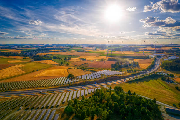 solar farm and wind turbines near the highway road interchange (aerial)