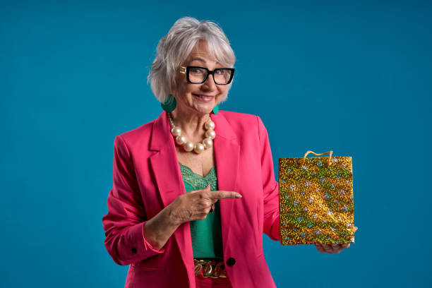 istock Cheerful senior presenting a glittering gift 2083327418