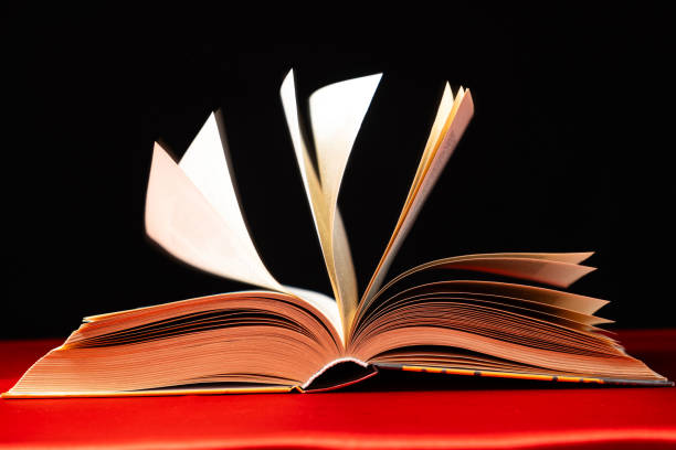 istock Pages of a thick book are turned on a red and black background. 2083368566