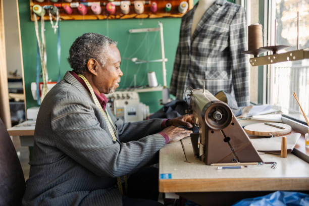 istock Latin senior man working as a tailor. He is working in the small tailoring shop. 2083385269