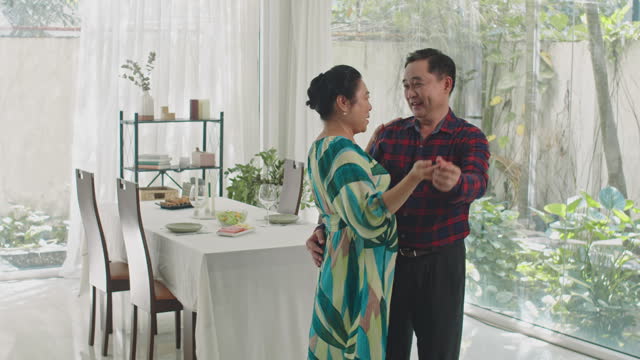 Aged Man and Woman Dancing before Dinner in Living Room
