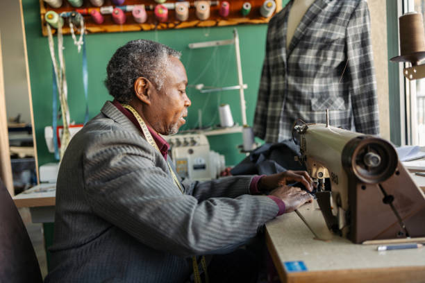 istock Latin senior man working as a tailor. He is working in the small tailoring shop. 2083386384