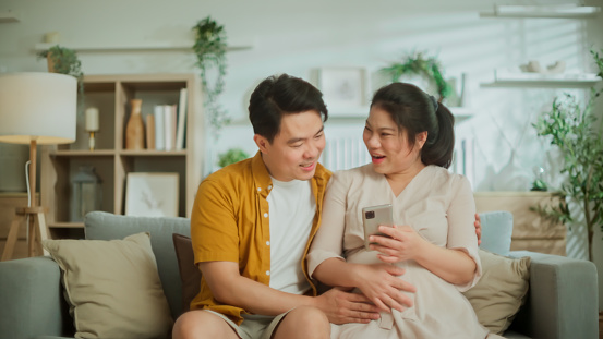 Loving Young asian Couple Spending wonderful moment together they sharing love conversation while looking at her ultrasound scan xray baby born together with love and emotion Loving Young Couple Spending Morning at home