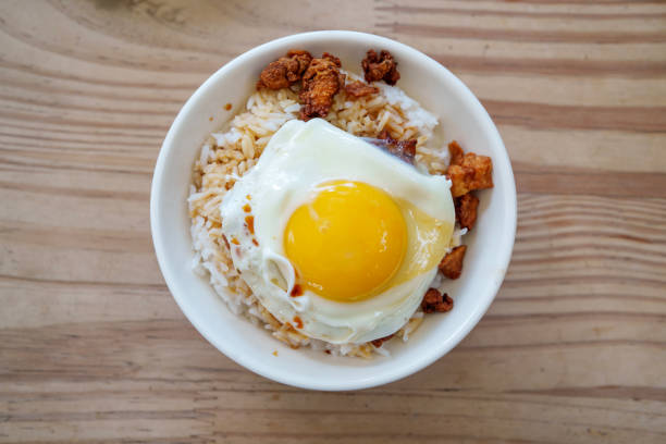 Crispy pork lard mixed rice with fried egg, served in a bowl.
