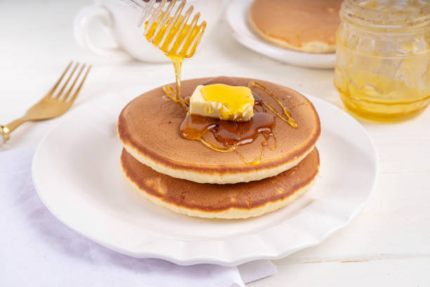 istock Pancakes with butter and honey or maple syrup drizzles 2083399996