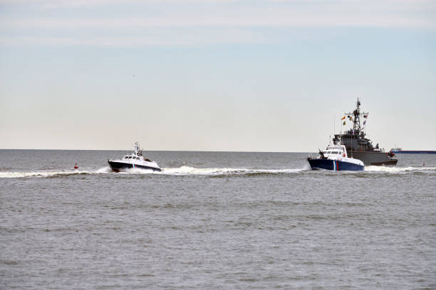 istock Coast guard ship escort russian warship that has trespassed state border along seaside 2083400407