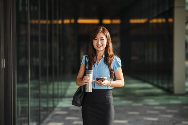 istock Tech-Savvy and Hydrated: Asian Businesswoman's City Hustle 2083404785