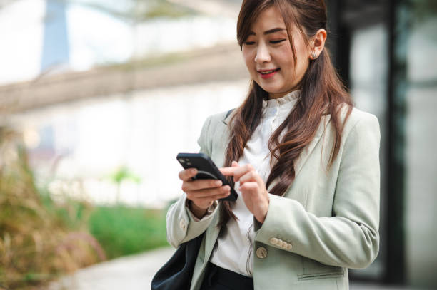 istock Asian Ambition: Businesswoman's Outdoor Phone Triumph 2083409562