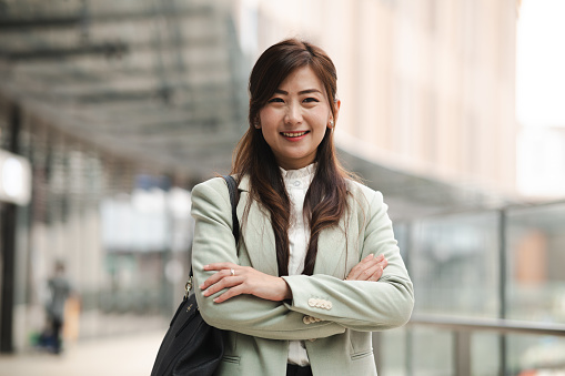 Portrait of a confident Asian Chinese businesswoman standing against an urban background