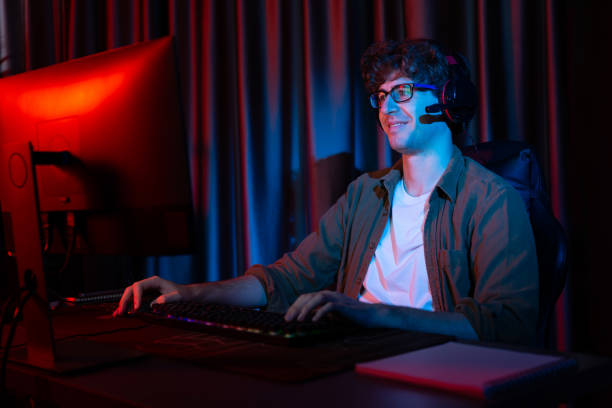 istock Smiling streamer with joystick, focusing Esport team on pc with harder. Gusher. 2083417548