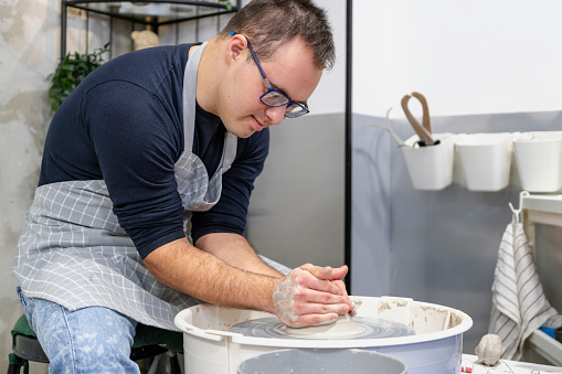Young man with Down Syndrome at pottery and terracotta workshop