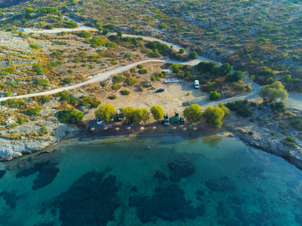 vista de drone rvs no estacionamento do acampamento perto da praia no litoral. caravana familiar sobre rodas pelo mar. viagem de estilo de vida ao mar. campervan ao longo da costa da turquia. estacionamento para caravanismo. acampamento. - beach parking lot car equipment - fotografias e filmes do acervo